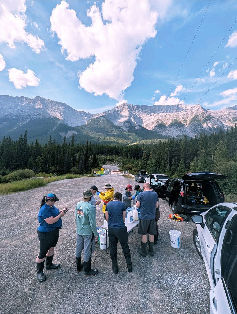A group of people standing on a road with mountains in the background
