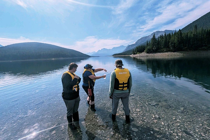 A group of people standing on a rocky shore