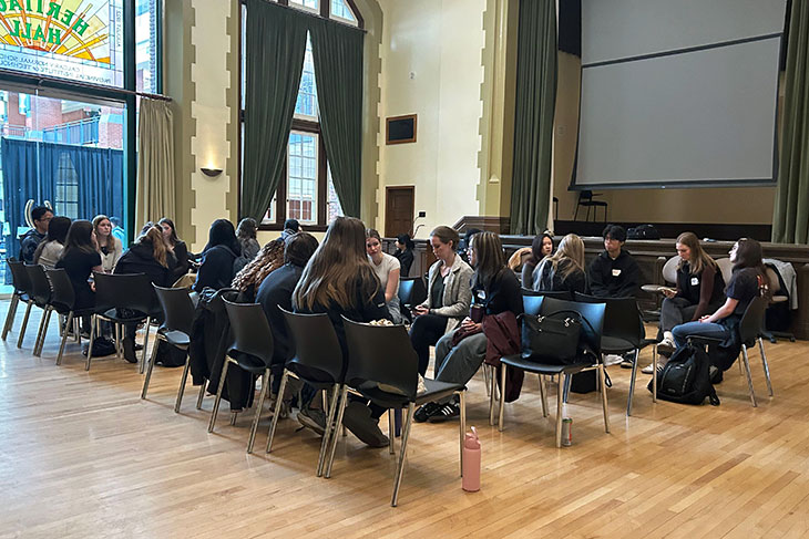 students in Macdonald Hall sitting in chairs facing each other in discussion