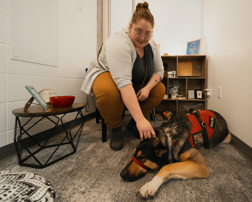 female student with support dog in room