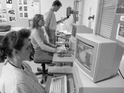 A black-and-white photo of students utilizing the Amiga Lab at SAIT, as it existed during 1990, as a part of the Cinema, Television, Stage and Radio (CTSR) program.