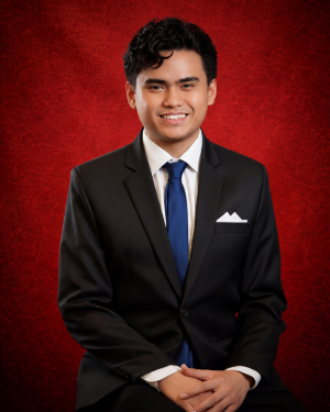 A headshot of Felix Montanez in front of a red backdrop.
