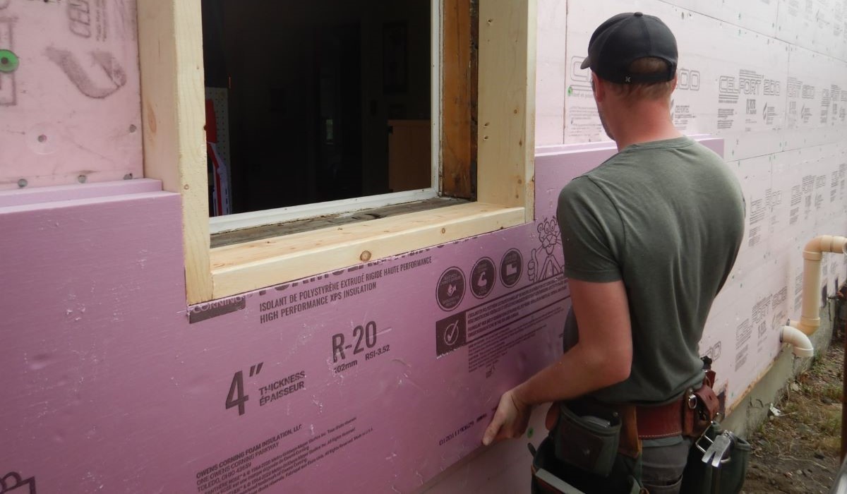 Contractor applying high-performance insulation during a deep energy retrofit