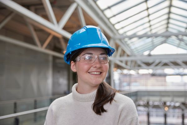 Women smiling while wearing a blue hard hat