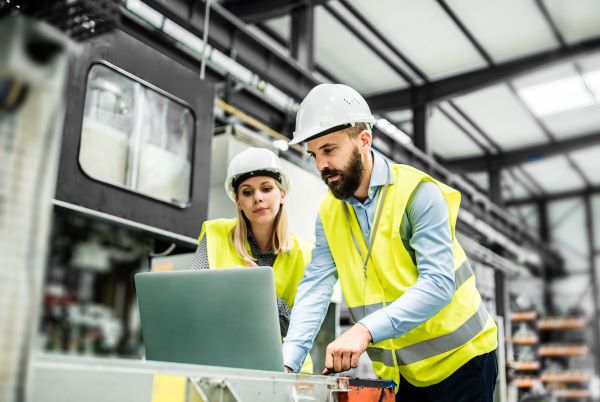 Two men working in a lab while wearing hard hats
