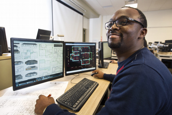 a man working on a computer while looking at a camera