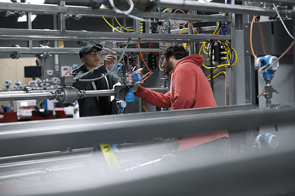 Two men working on a pipe system