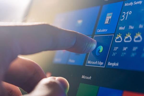 A close-up of a hand selecting a Microsoft app on an Android phone.