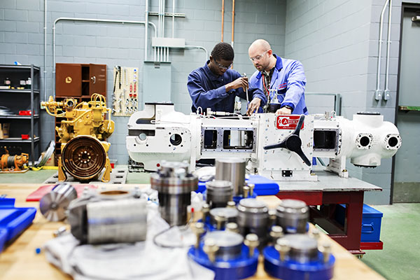 Two students focused on fixing a motor