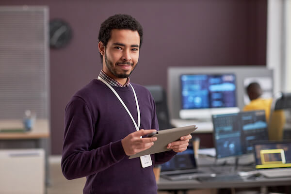 A man holding an ipad in a computer lab