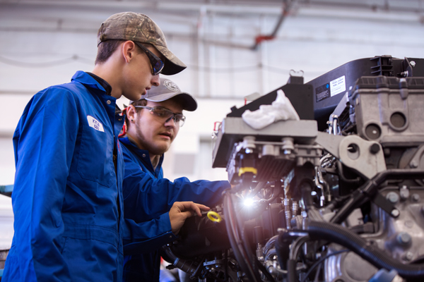 A student works on heavy equipment in a lab.