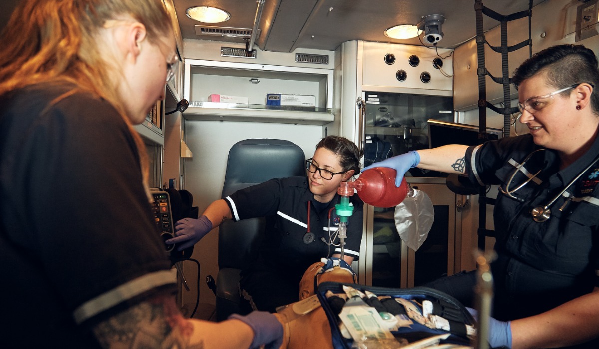 Paramedics providing emergency medical care to a patient in an ambulance.