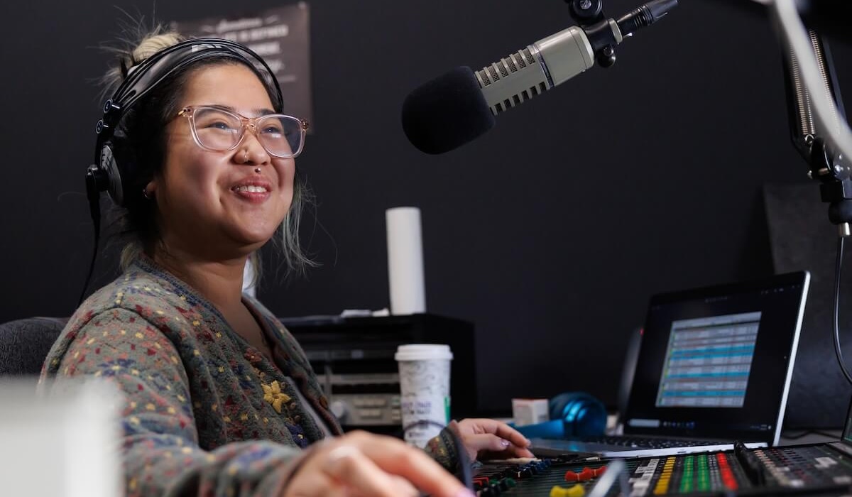 Student wearing a headset sitting in an audio booth