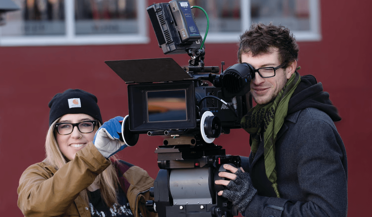 Two people working with a camera outside