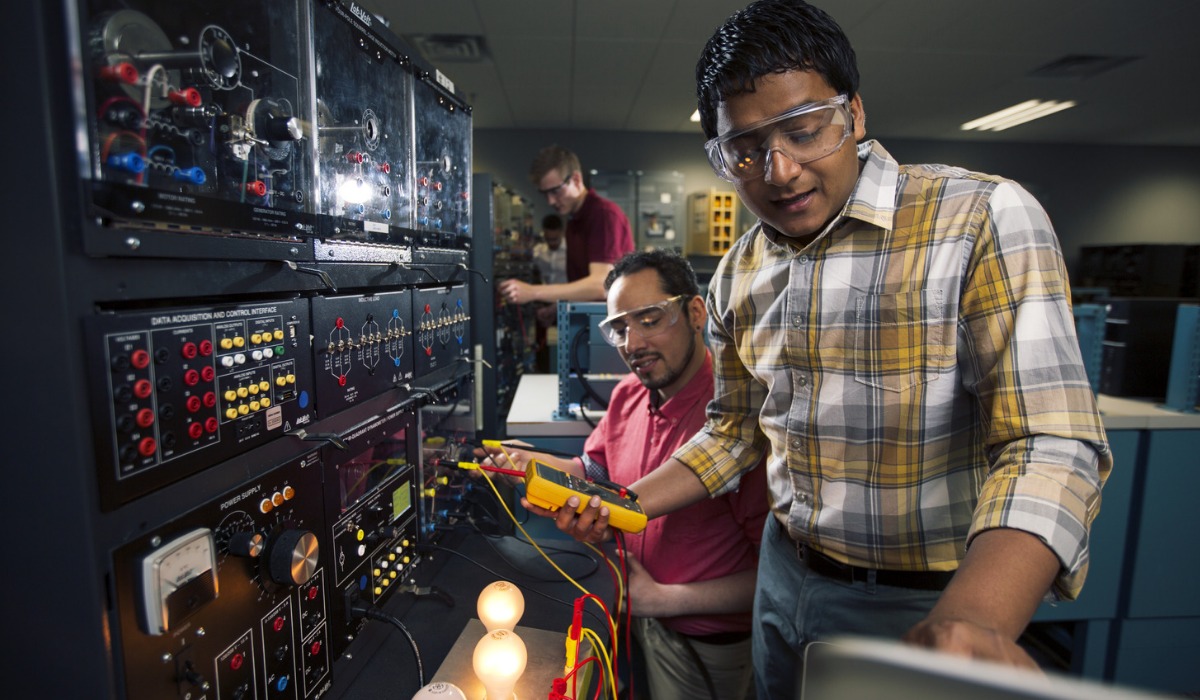 Students conducting experiments with electrical equipment in a lab setting.