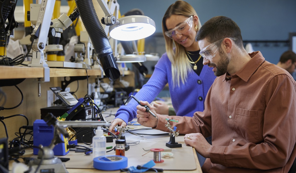 Students engaged in hands-on electronics work at a lab, using tools and materials to build projects.
