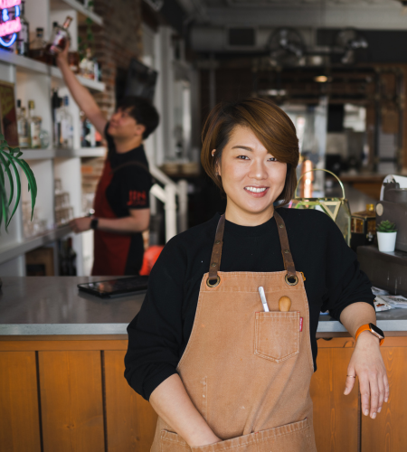 young Asian woman wearing a cooking smock smiling