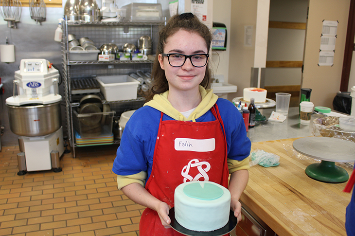 Faith Mahoney shows the cake she is working on