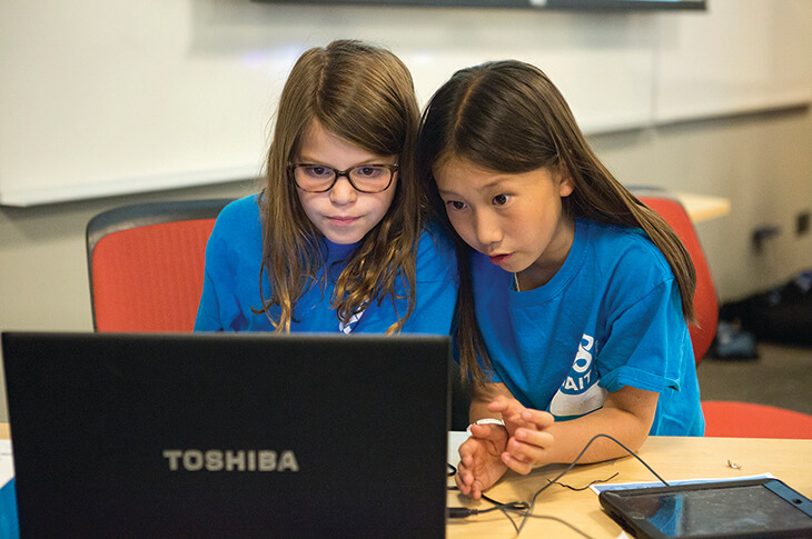 Two young Summer Campers share a laptop.