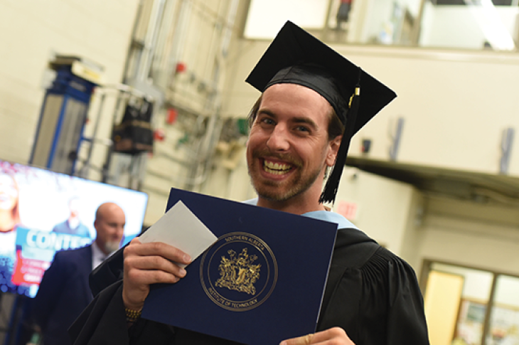 A graduating student smiling