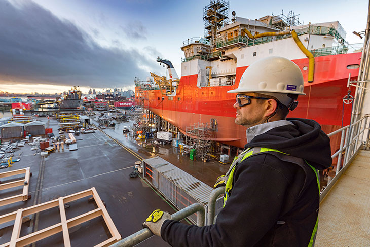 Ryan Logan wearing safety gear as he over looks Seaspan work site.