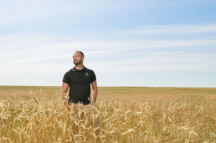Rob Avis, a male Caucasian with athletic build standing in a field looking off to the left of the screen.