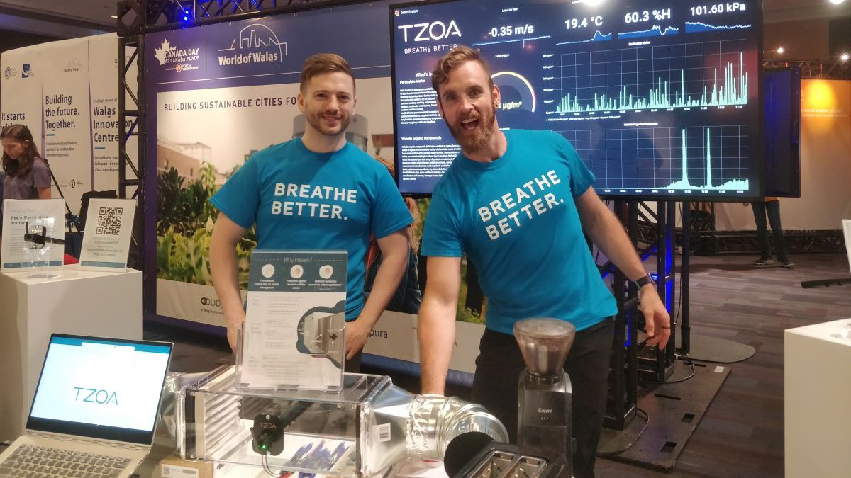 Two men standing at booth in blue t-shirts