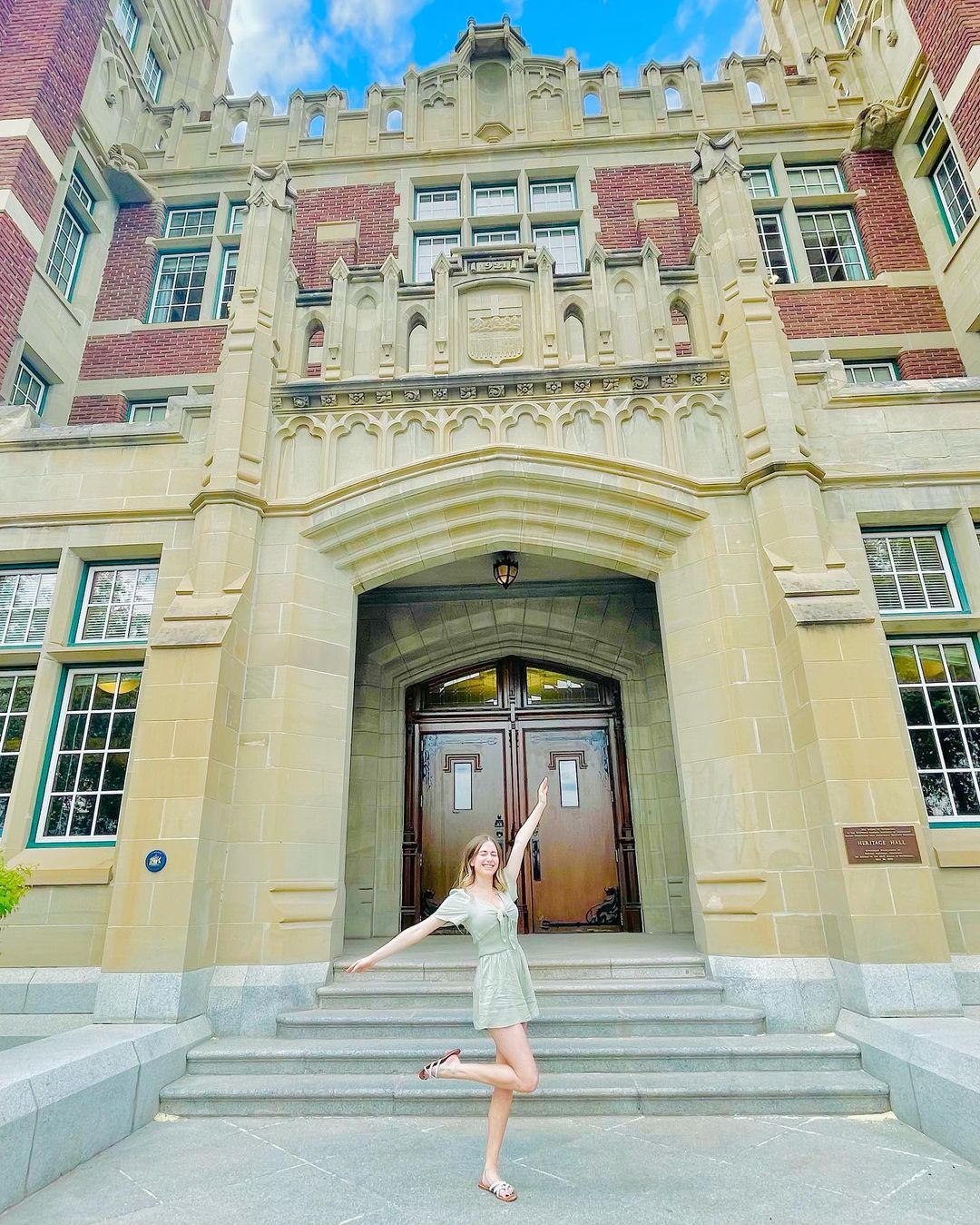 SAIT student posing in front of heritage hall