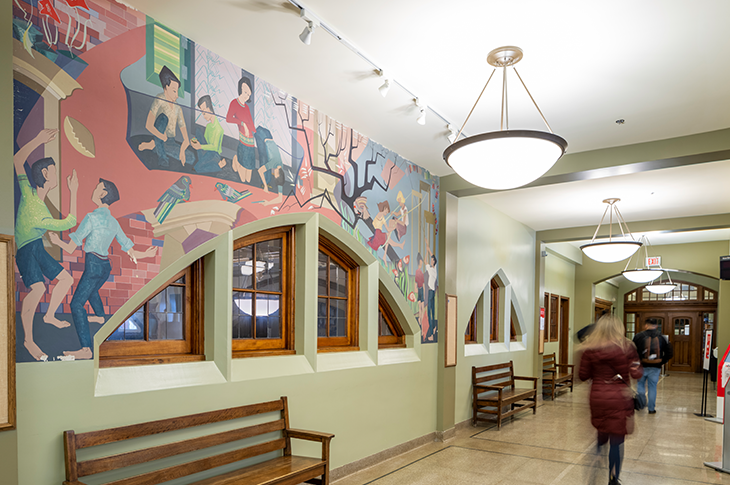 Photo of mural with people walking by 