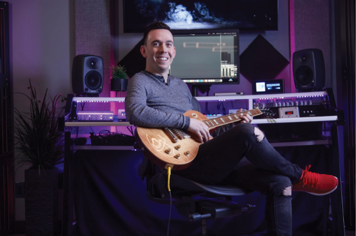 Ron Tarrant holding a guitar in a studio