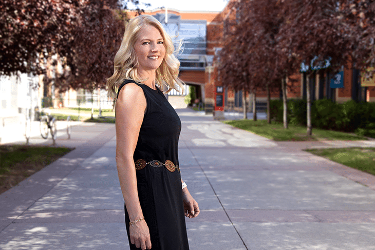 Linda Olsen turning over shoulder to look at camera wearing a black dress