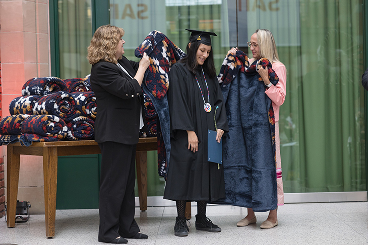 SAIT executives wrap a student in a blanket