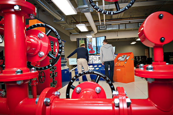 An instructor and student work at the drilling simulator in the Johnson-Cobbe Energy Centre.
