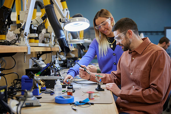 Two Electronics Engineering students work in a SAIT electrical lab.