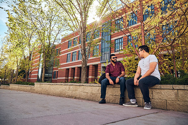 Two men sit outside the Stan Grad Centre.