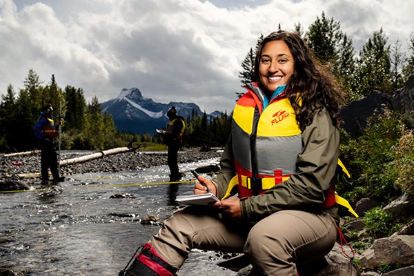 Woman holding a notebook in a river in Kananaskis