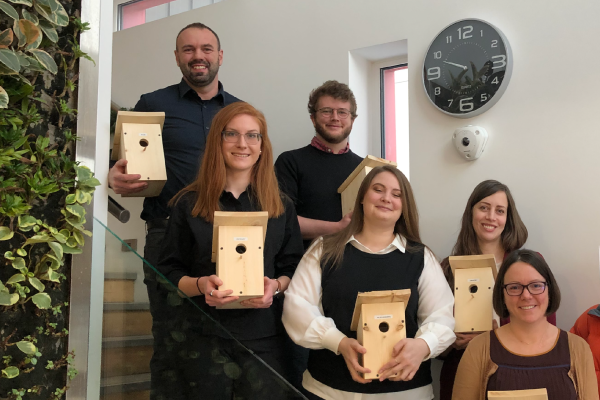 Group photo of people with birdhouses