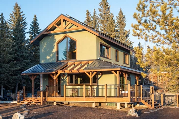 The exterior is designed to harmonize with the natural environment with the use of green ‘Secret Path’ stucco and rustic fir timbers.