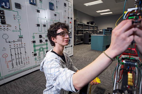 A student adjusting a control board in a lab