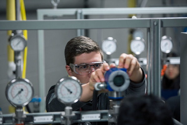 A student adjusting a gauge in a lab