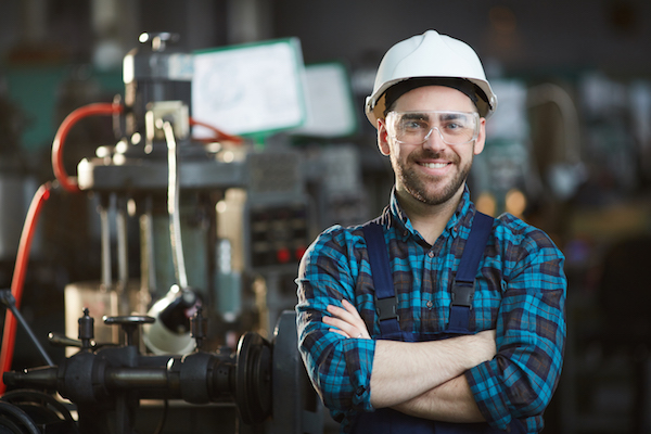 Man in hardhat with arms crossed smiling