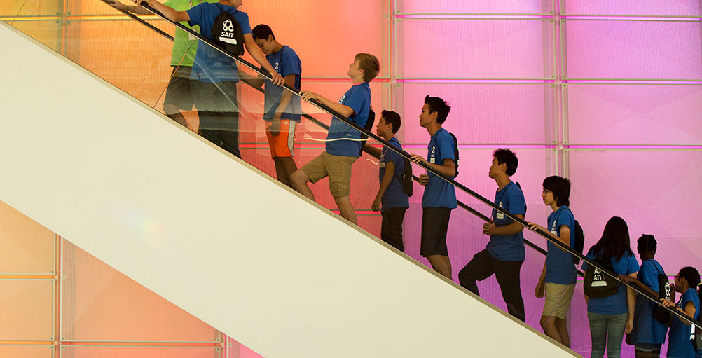 Students going up escalator 