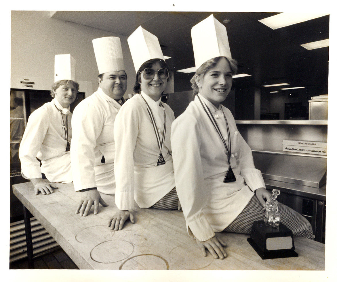 A group of four SAIT culinary students seated for an informal photo after winning student awards in 1985
