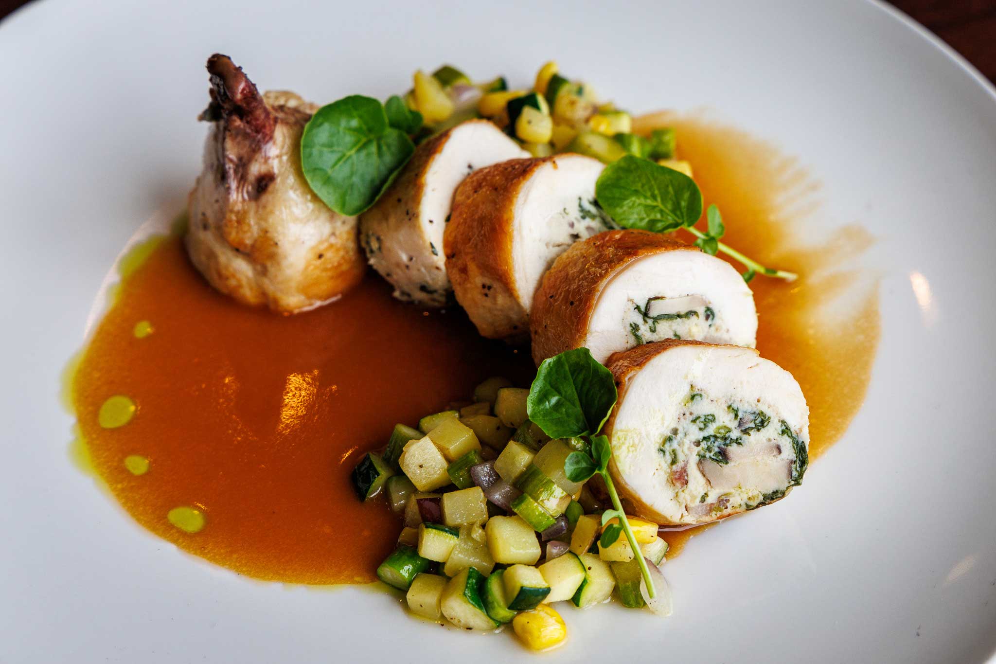 Chicken ballotine stuffed with mushroom mousseline, served with succotash and sauce supreme