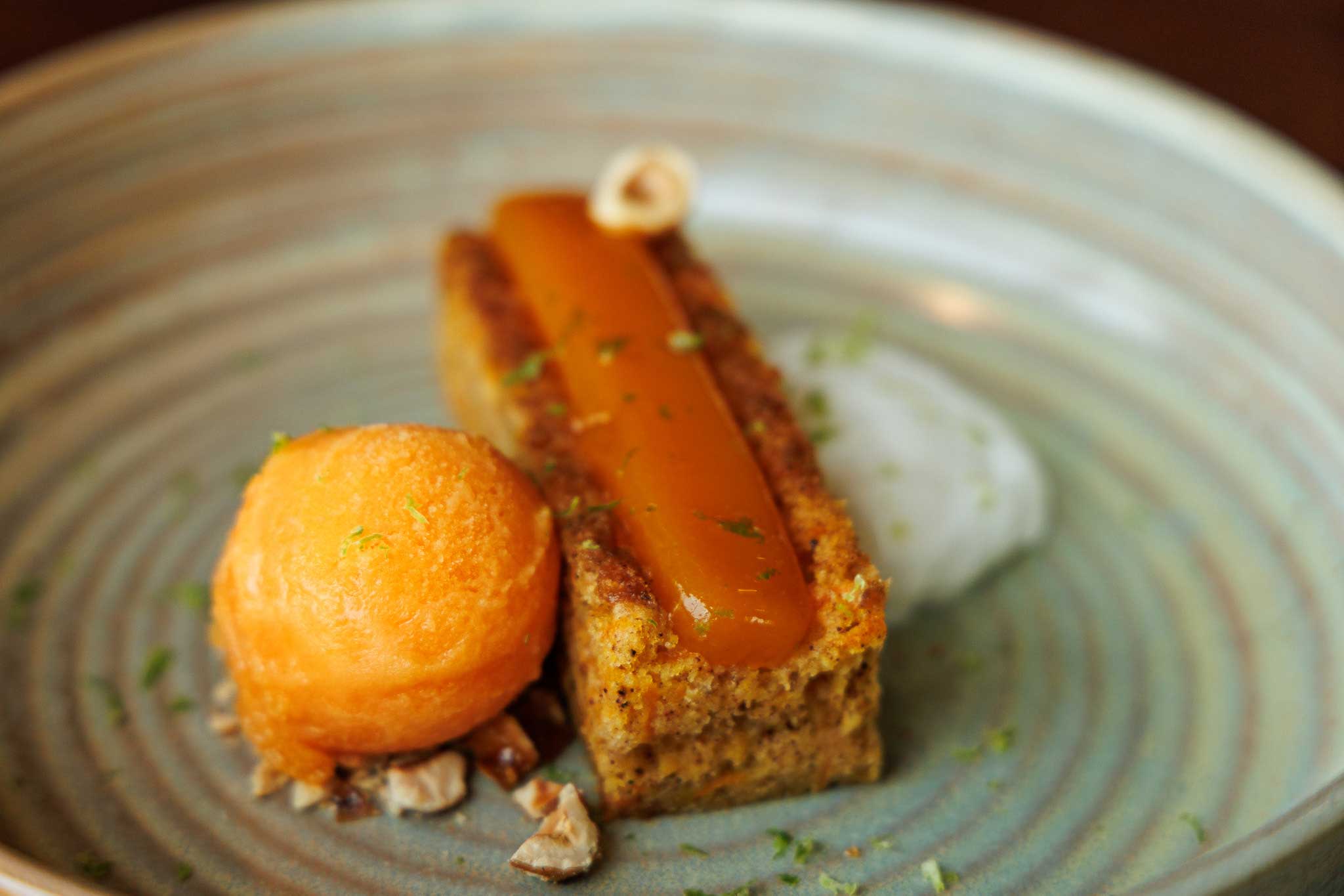 carrot cake served with orange-carrot sorbet, coconut cream, and passion fruit gelee