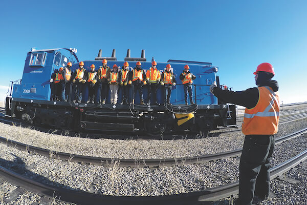 A group of students stand on a rail car at SAIT's Centre for Rail Training and Technology