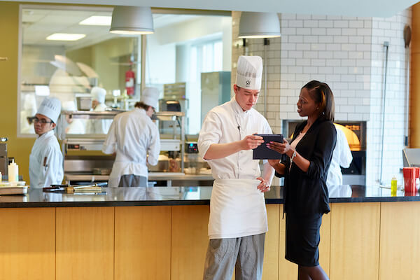 Student chef chatting with professionally dressed woman