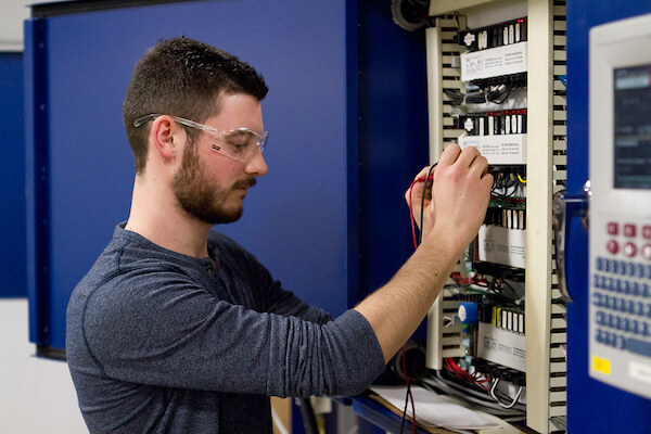 A man works on a circuit breaker