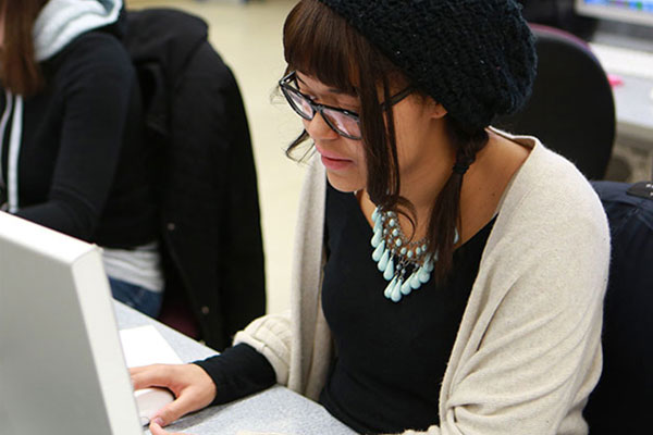 A young woman works on a computer in a lab.