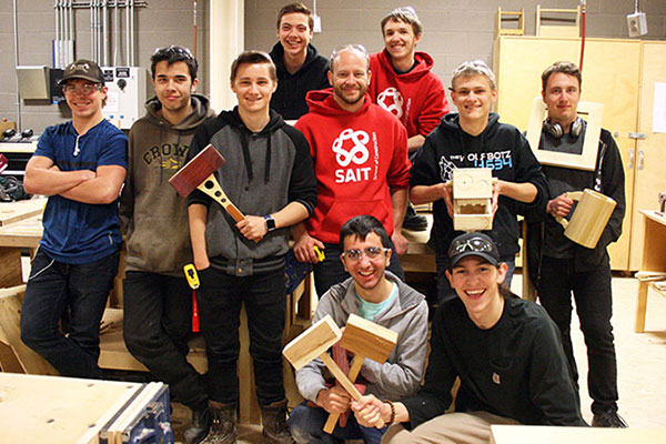 A class photo of dual-credit Carpentry students in a SAIT lab.